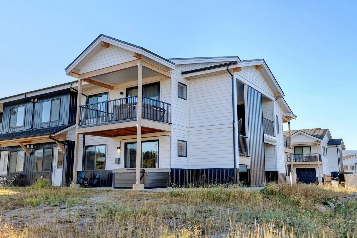 This exterior shot highlights a spacious balcony with modern architecture and large windows, ideal for lounging or morning coffee. The balcony offers clear views of the surrounding natural landscape, creating a seamless transition between interior comfort and outdoor adventure.