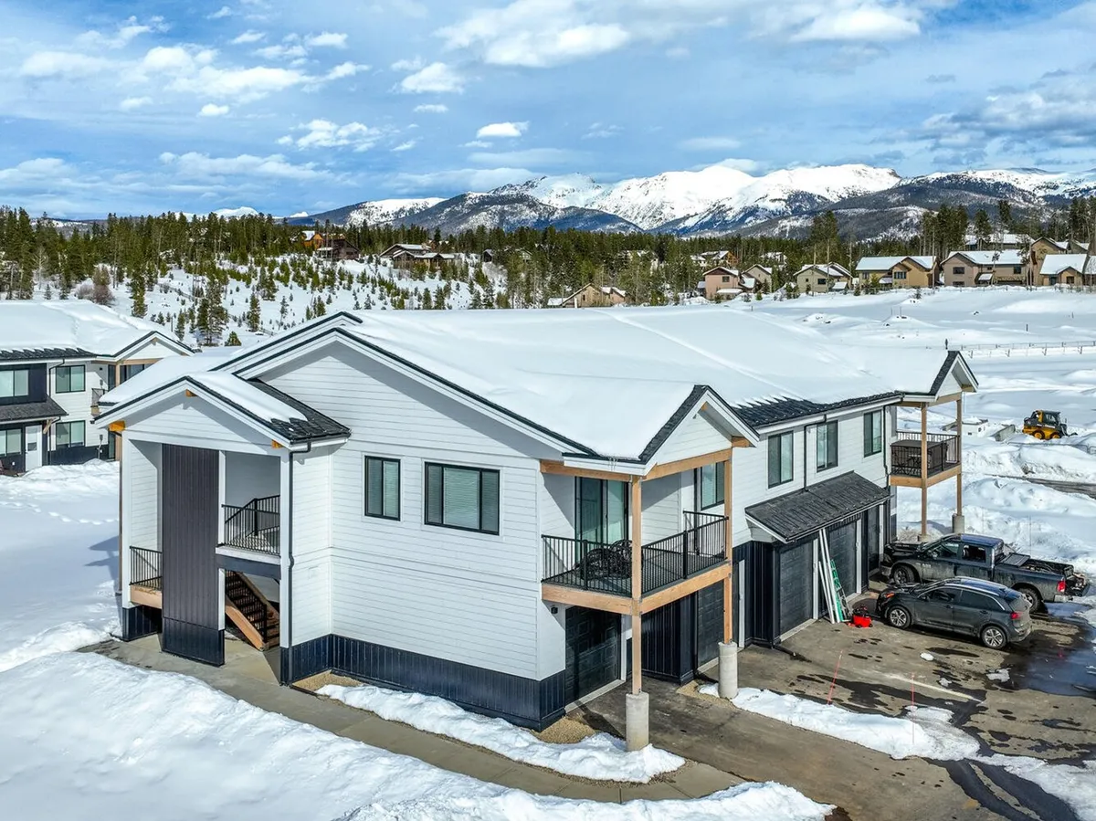 A stunning exterior shot of the condo set against a dramatic snow-covered landscape, with mountains in the backdrop. The modern architecture stands out, emphasizing both the proximity to wilderness and the refined comfort of the property. The image conveys a sense of tranquility and adventure, inviting guests to experience both relaxation and outdoor exploration.